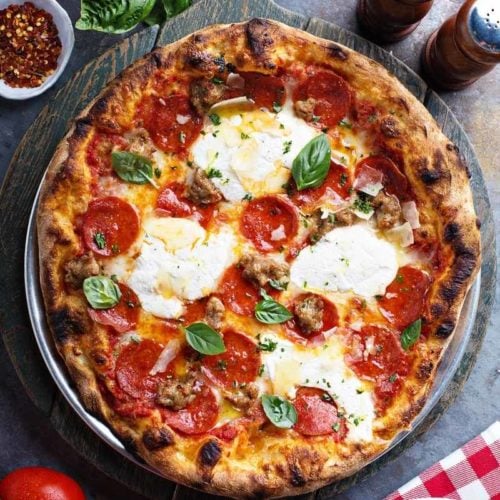 pizza crust with salad, spices, and tomatoes.