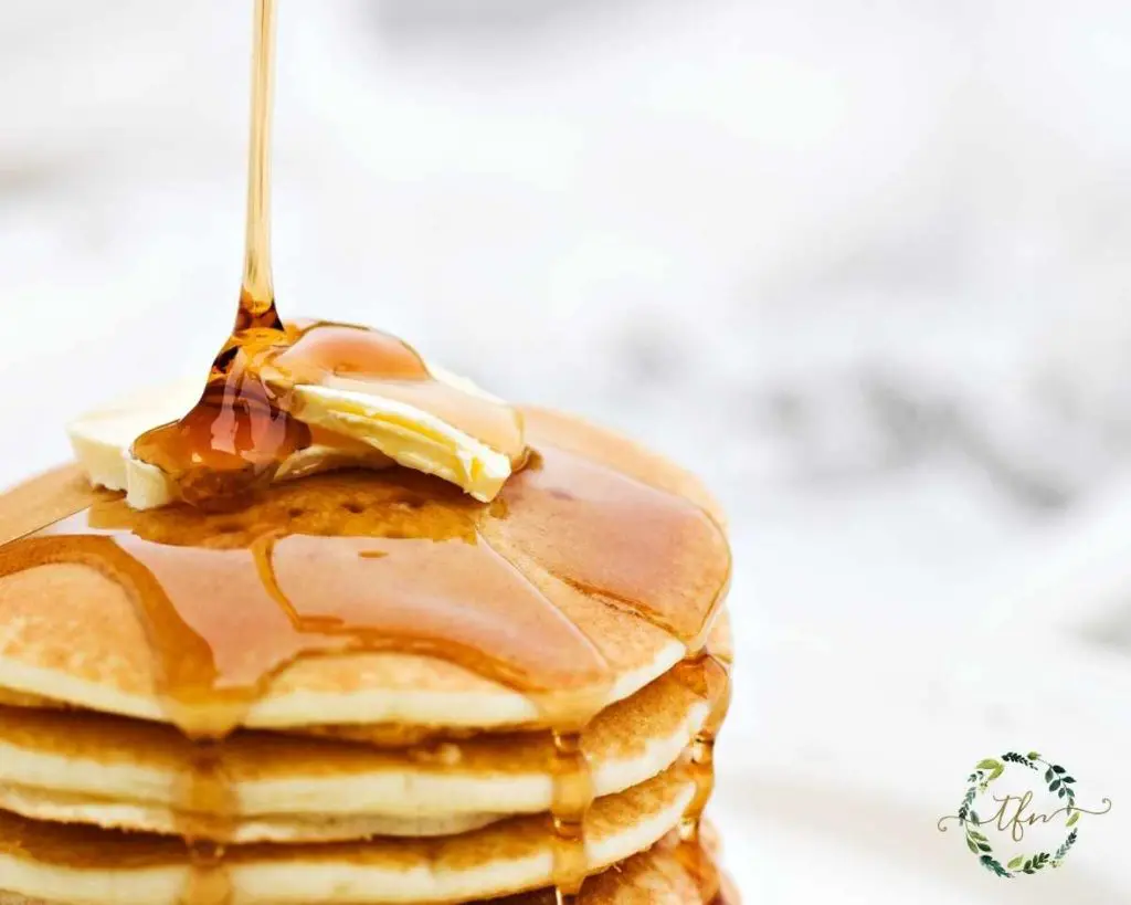pouring syrup on a stack of Bisquick pancakes