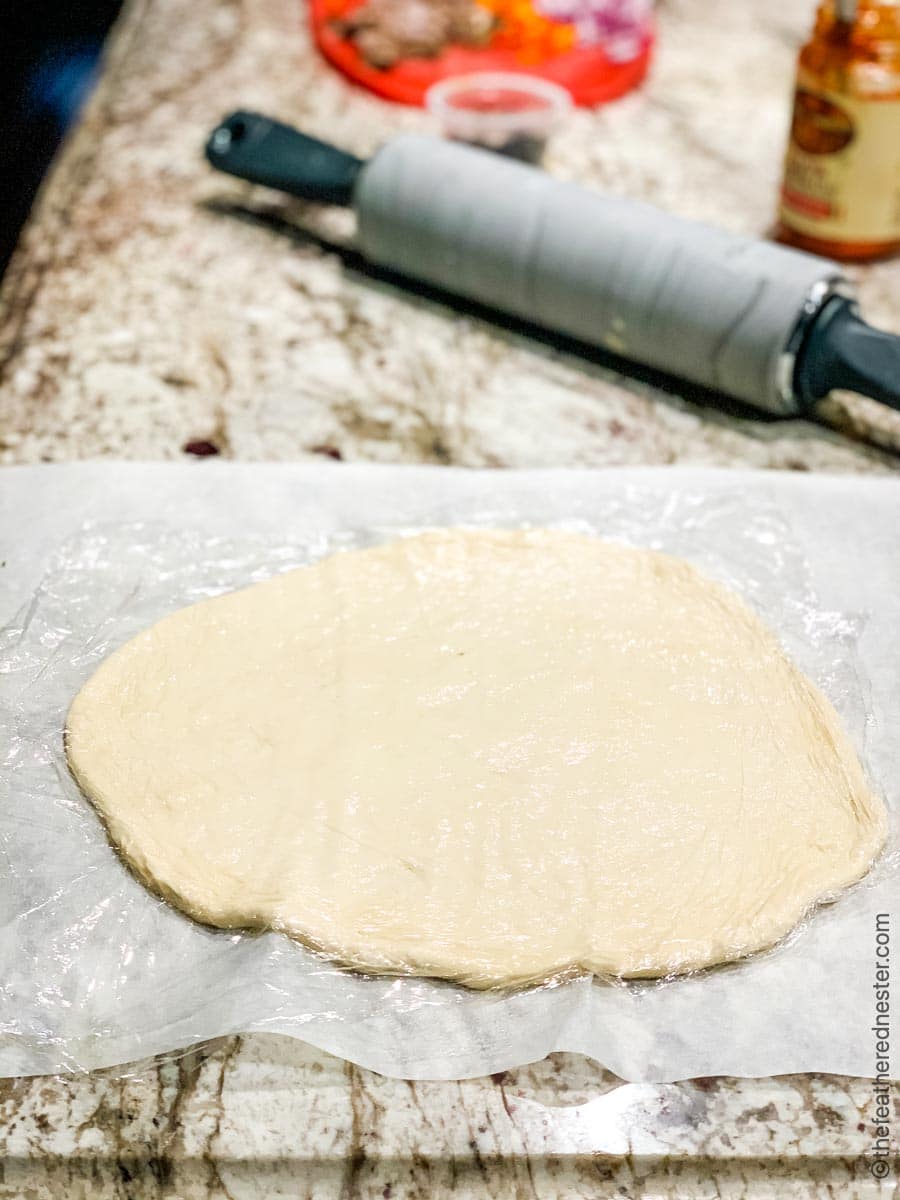 rolled out pizza dough on a counter.