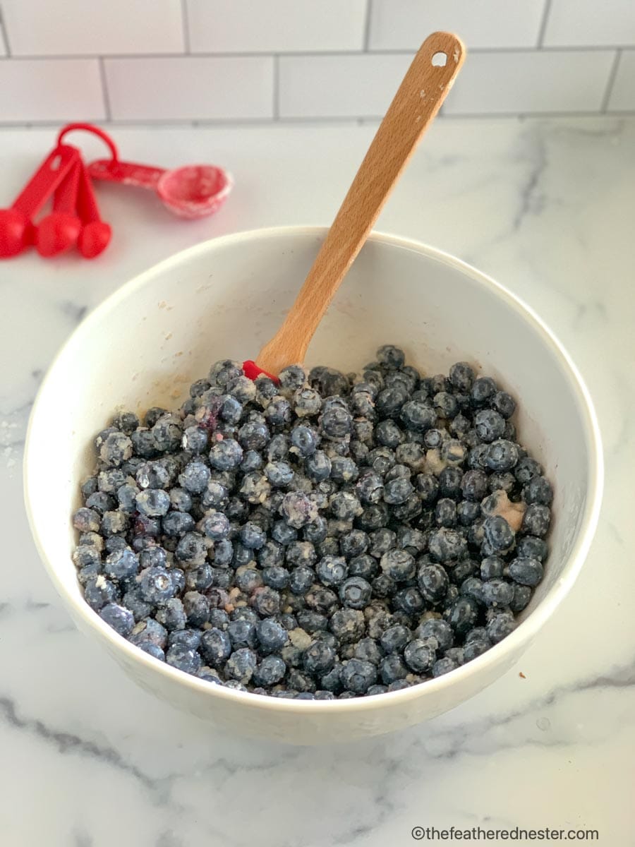 a mixing bowl with blueberries, sugar, lemon juice, and corn starch