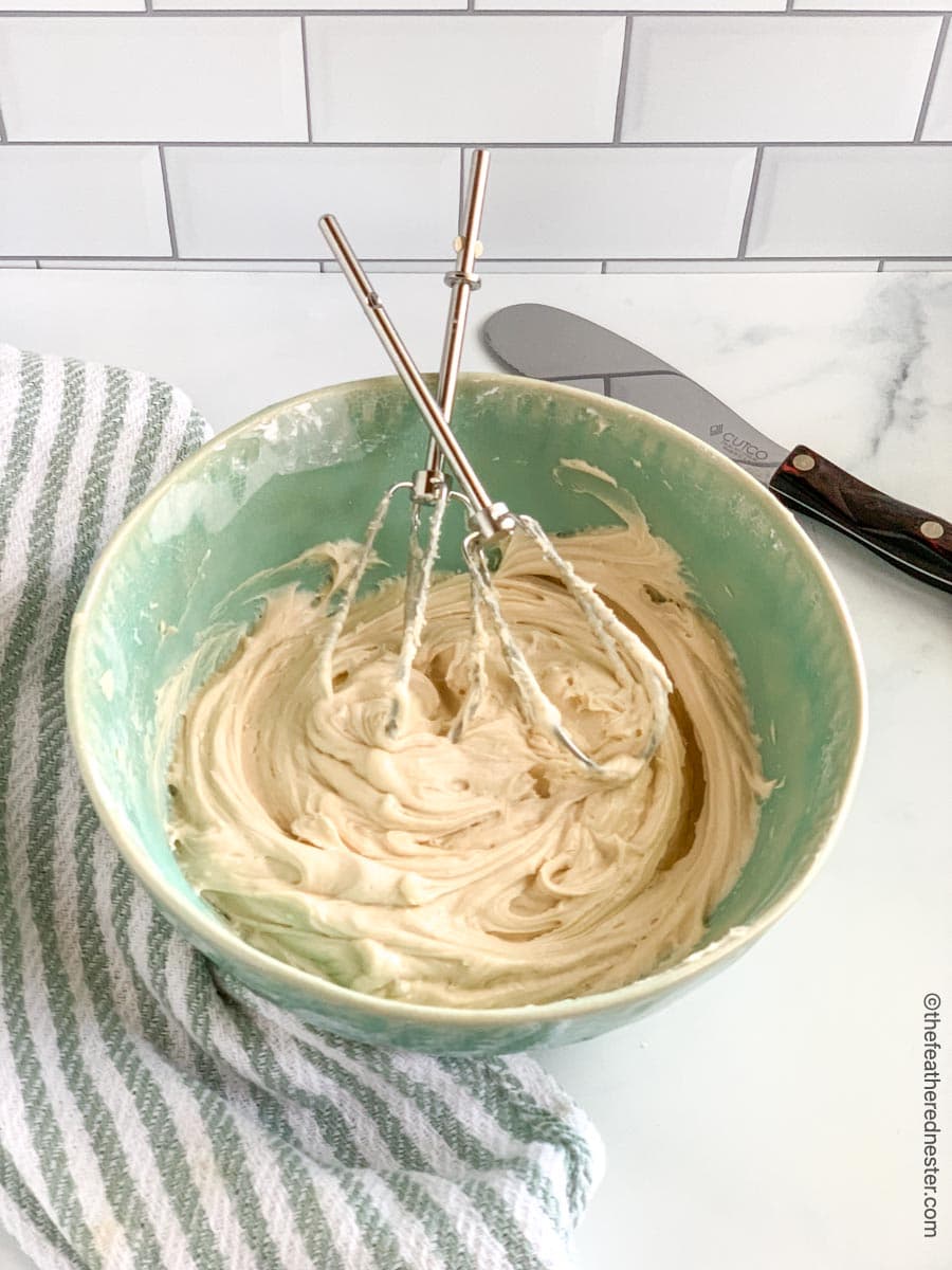 A green bowl with mixing beaters and sourdough cake batter.