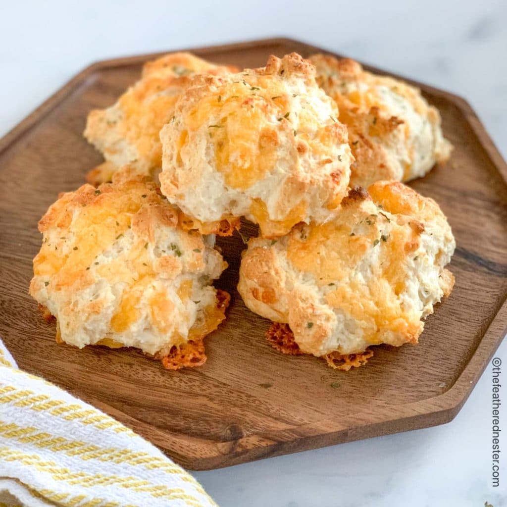 a wooden platter of cheese drop biscuits