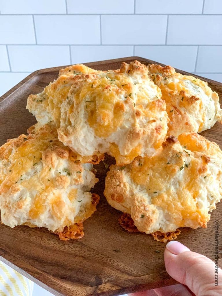 Bisquick cheddar bay biscuits on a wooden serving platter.