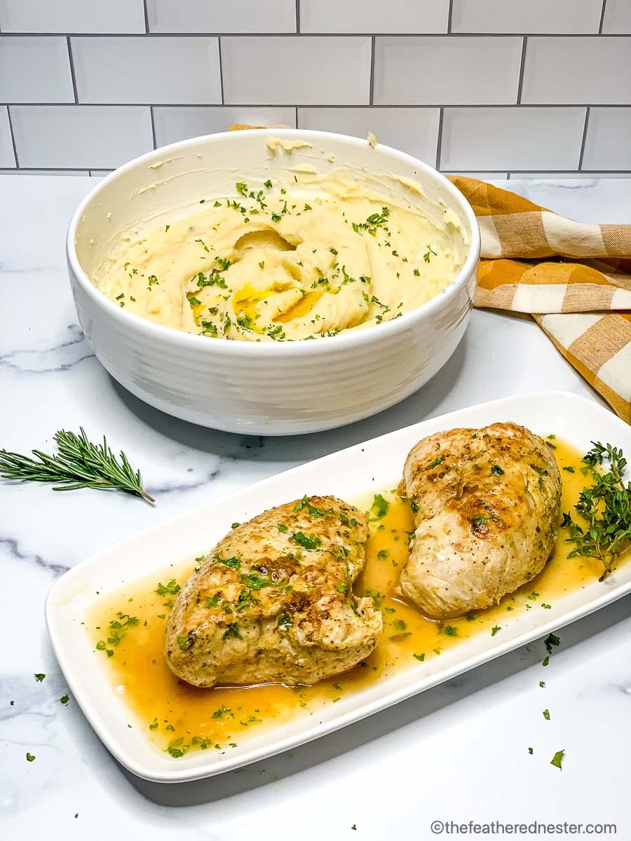 A platter of turkey breast tenderloin with gravy, next to a bowl mashed potatoes.