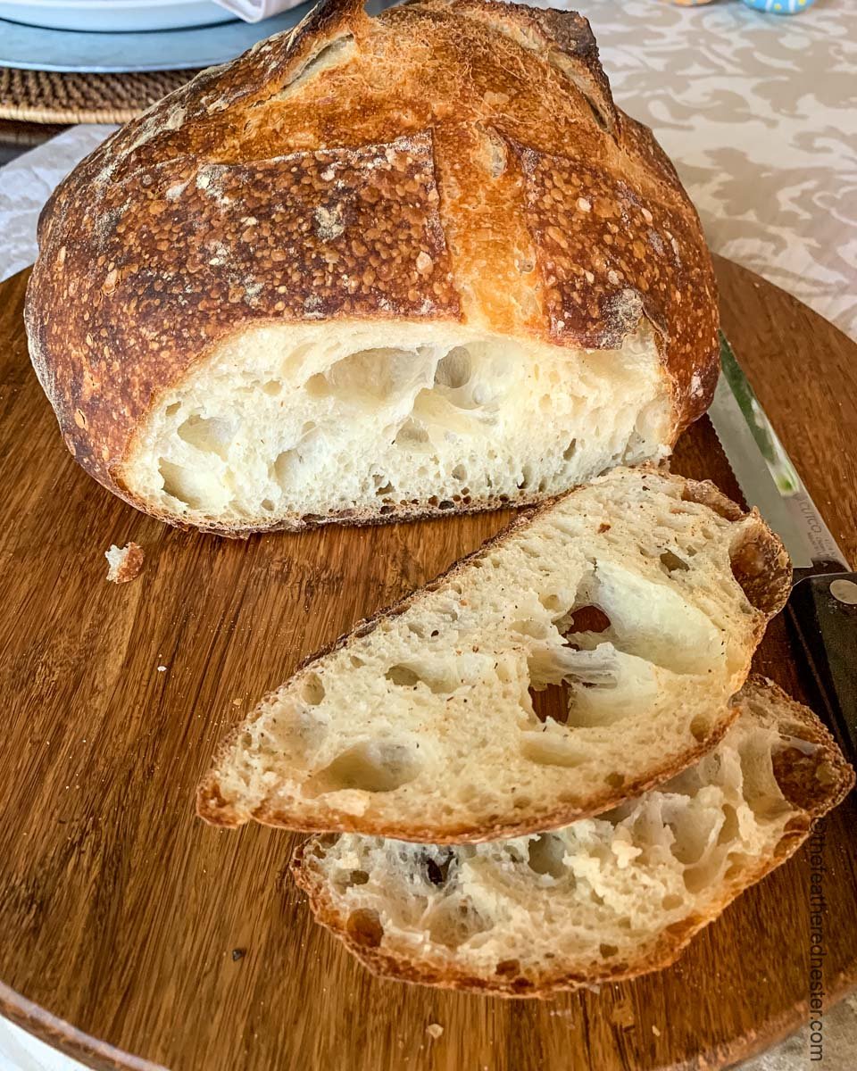 A sliced loaf of sourdough bread baked in a dutch oven.