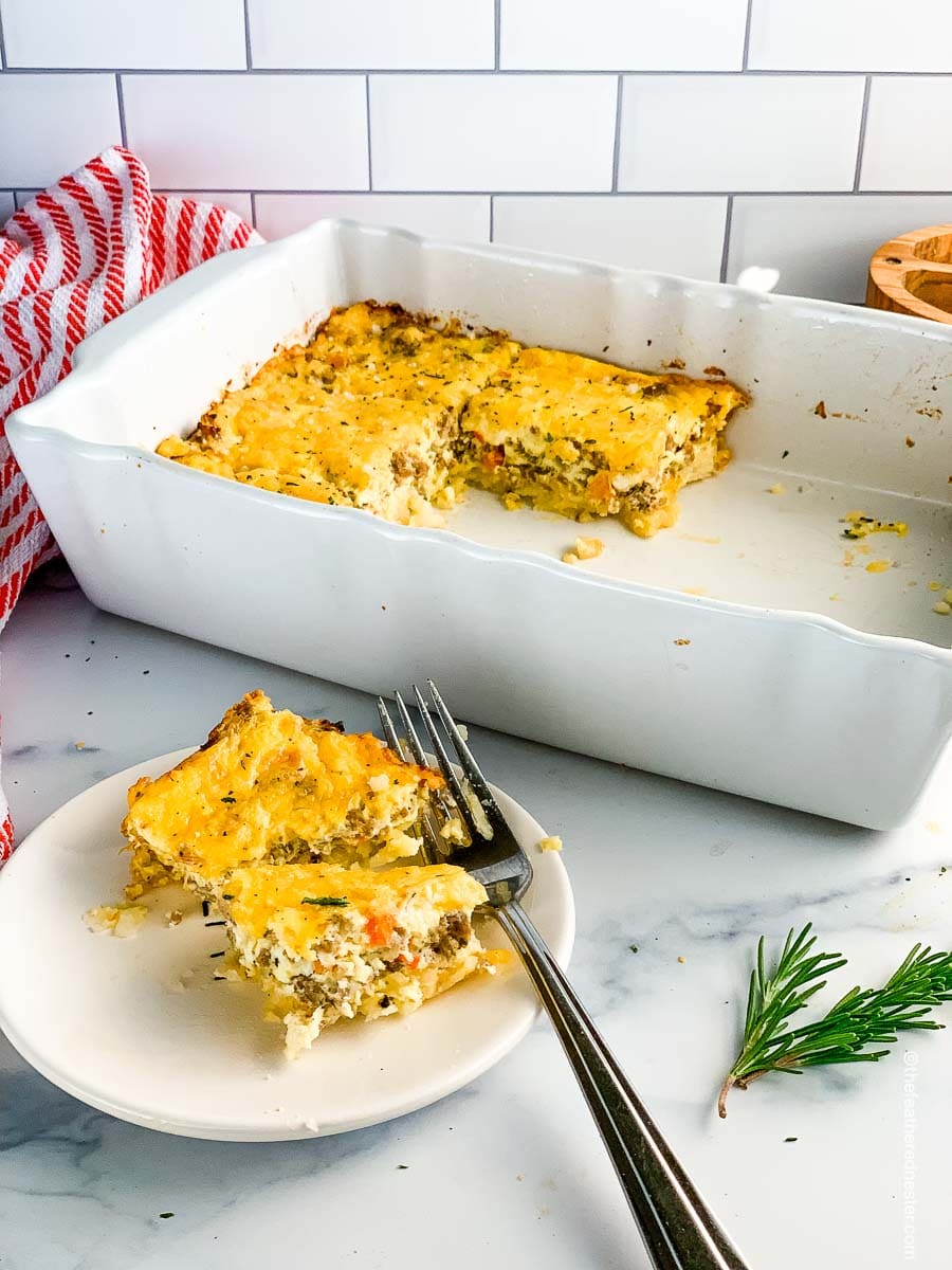 a casserole dish of hash brown casserole with a plate of the egg casserole ready to serve