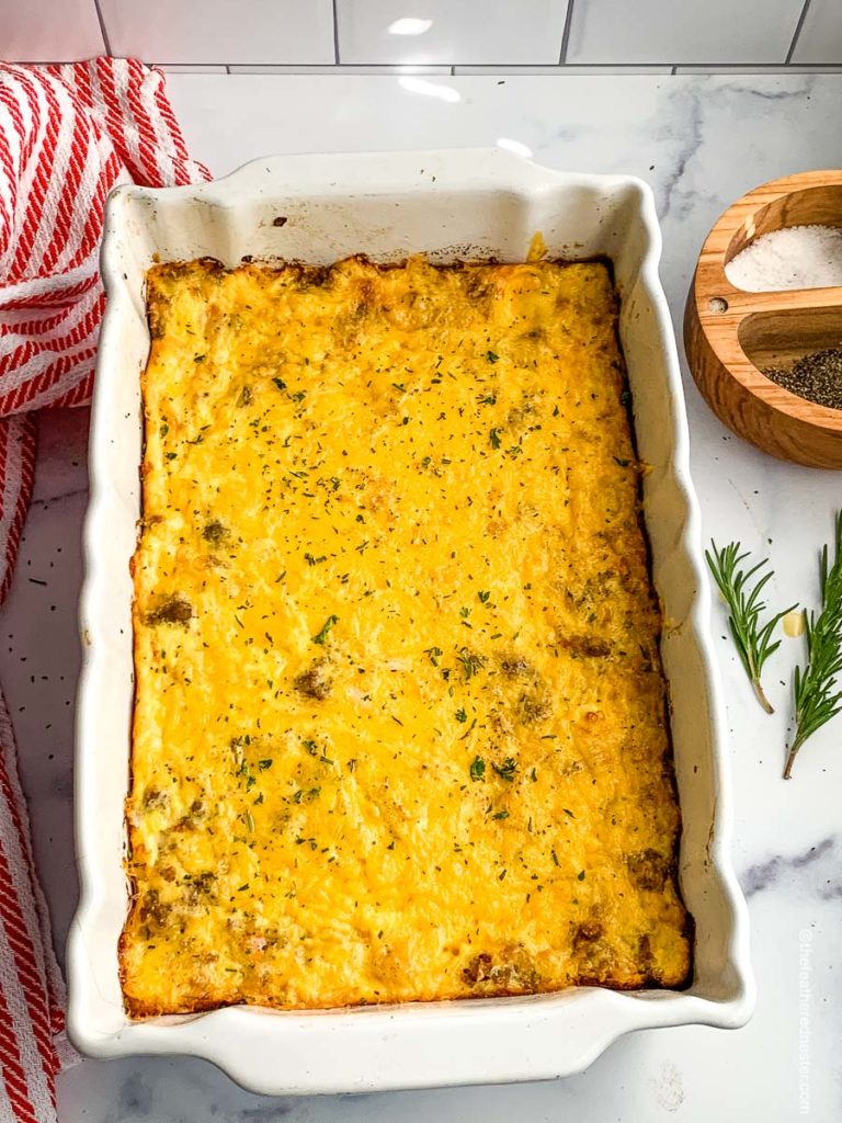 a casserole dish of hash brown and shredded cheese ready to bake