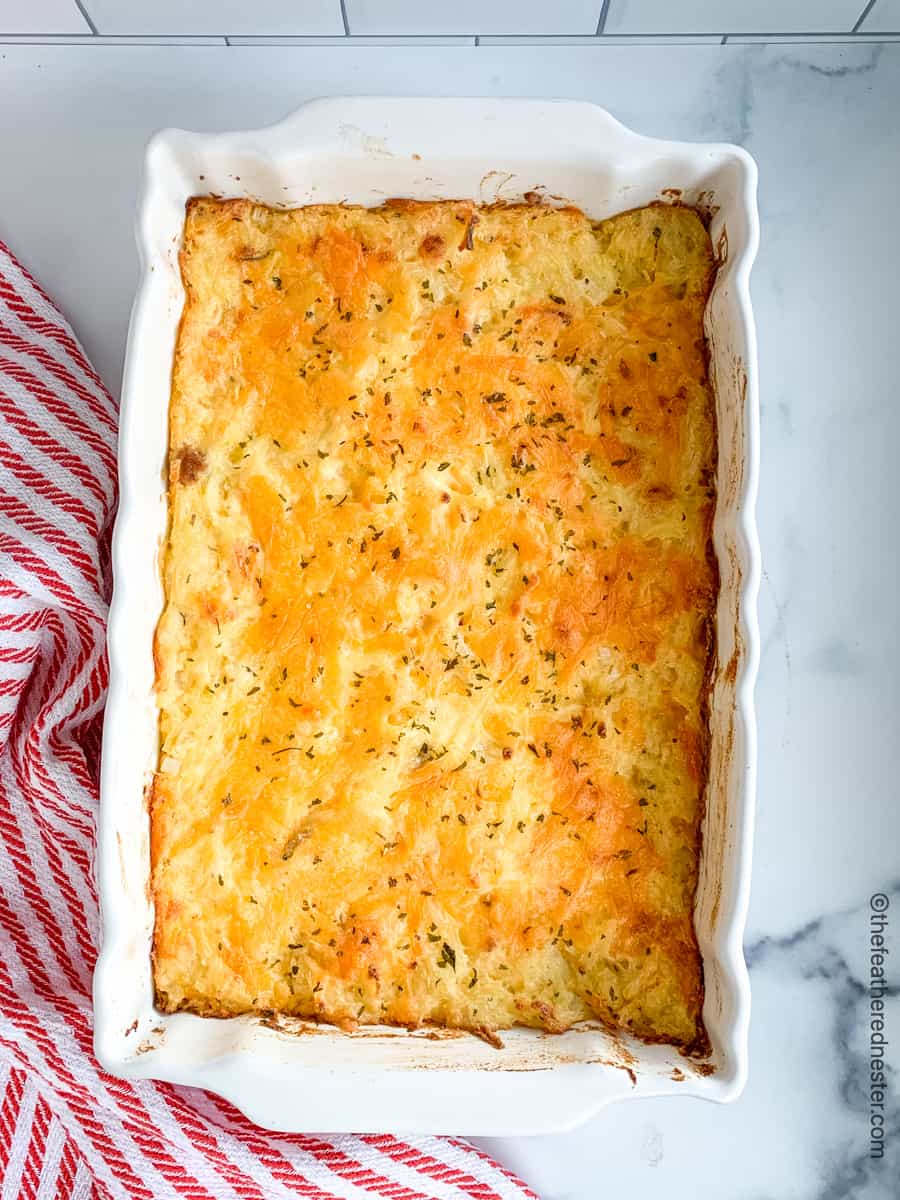 a white casserole dish of hash brown casserole.