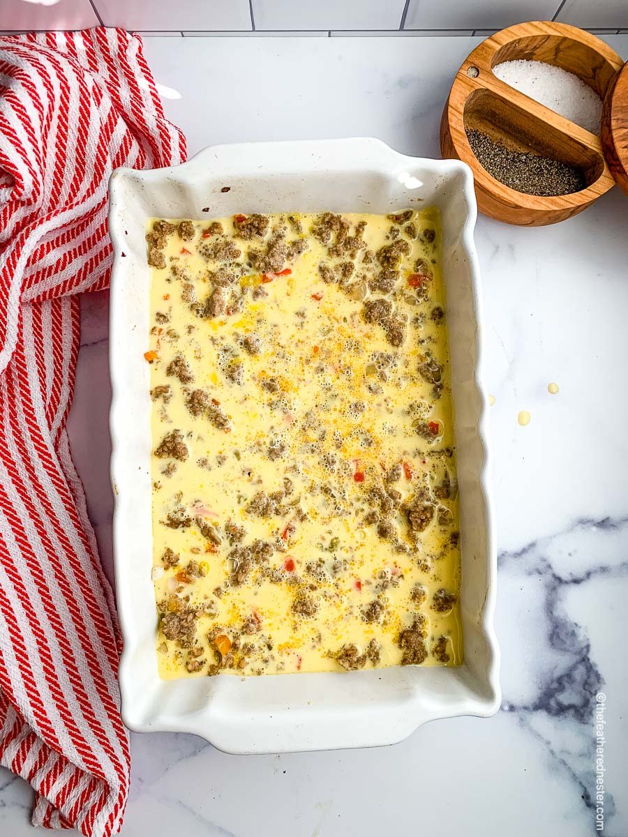 a casserole dish with egg and sausage casserole ready to bake.