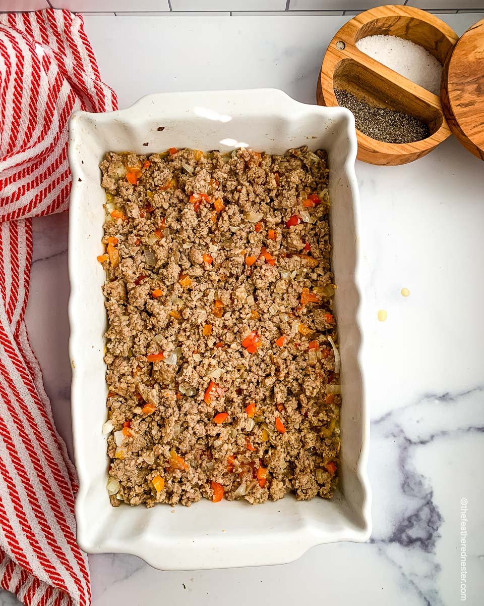 a casserole dish of ground sausage and potatoes ready to bake.