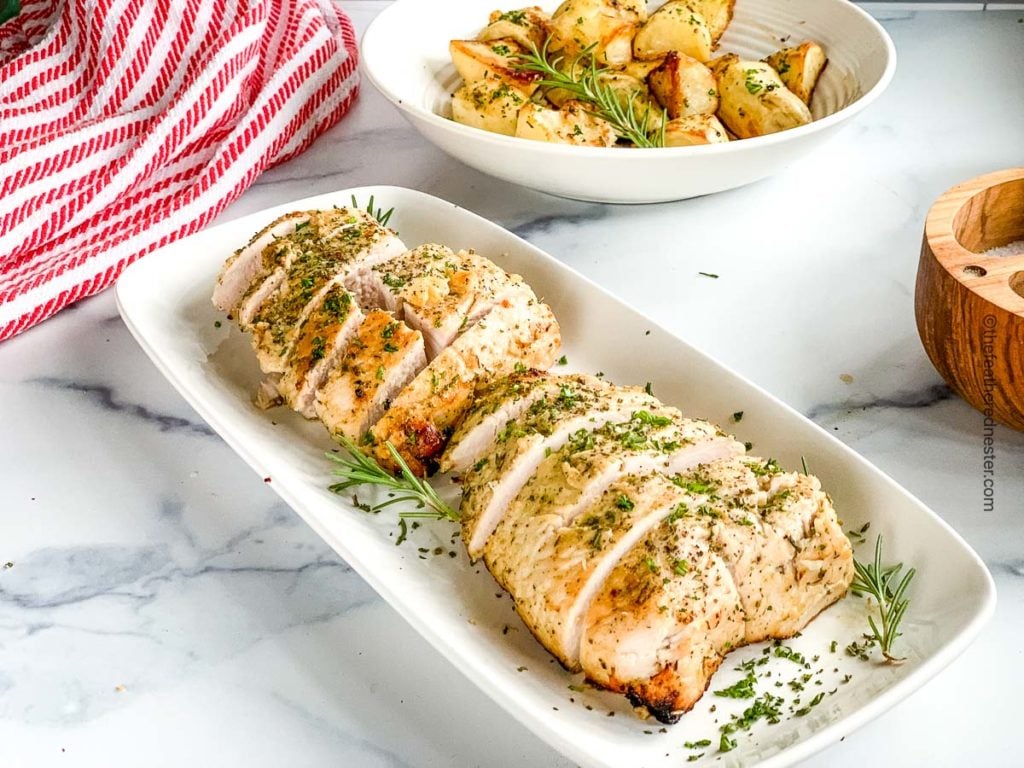 A sliced roast on a white platter, ready to serve