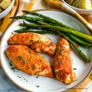 a plate of healthy baked chicken and asparagus.