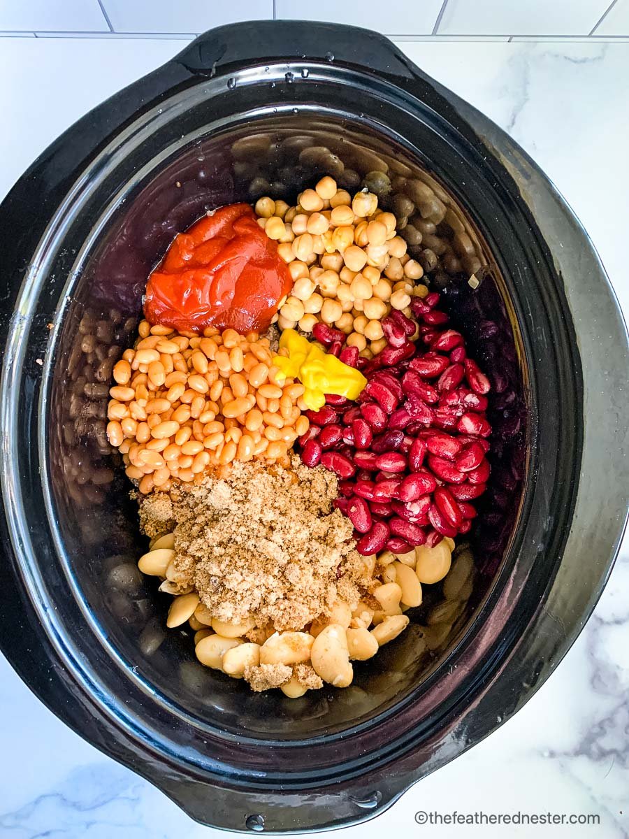 a slow cooker full of canned beans, ground beef, onions, and spices to make crock pot beans