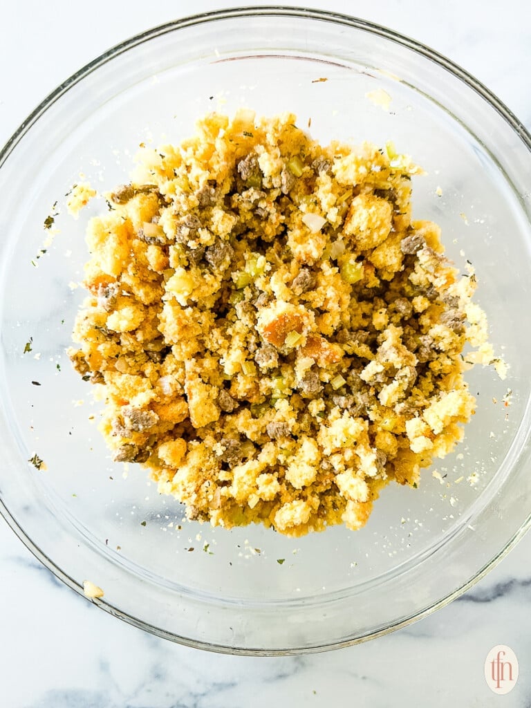Bowl filled with crumbled cornbread and sausage.