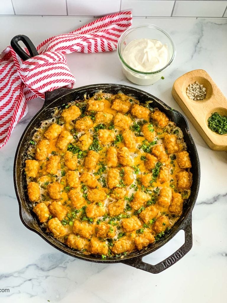 Chicken tater tot casserole with broccoli baked in a cast iron skillet.