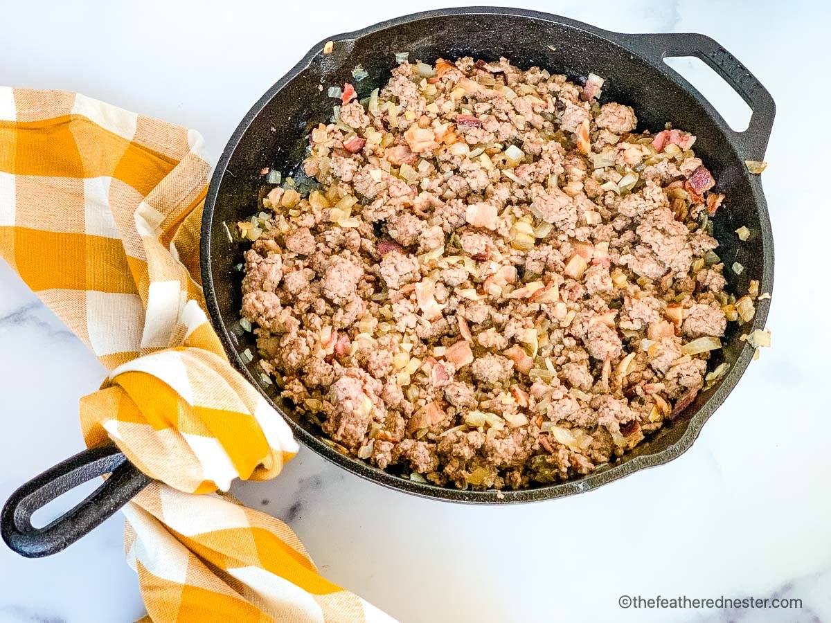 a skillet of ground beef, bacon, and onions