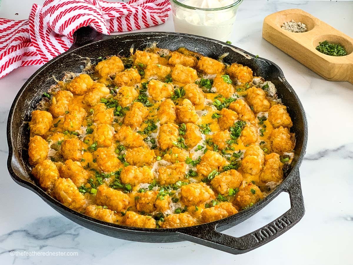 A skillet of beefy green bean casserole with Tater Tots