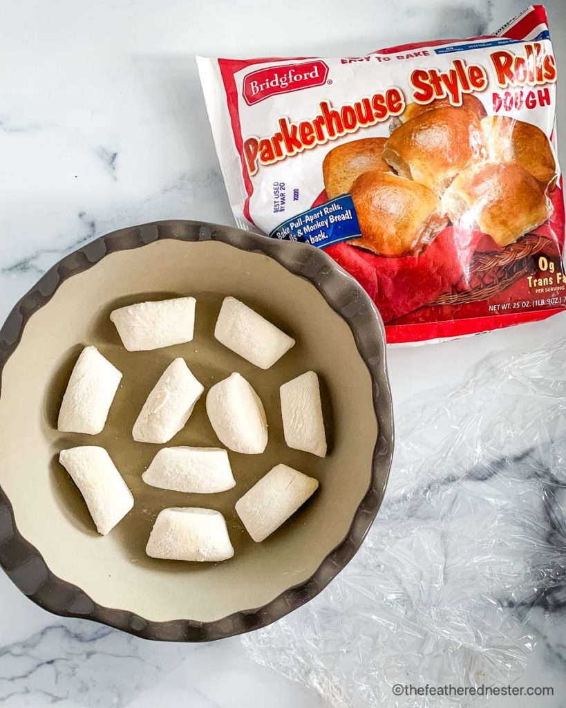 a pie plate of frozen Bridgford Parkerhouse Rolls thawing