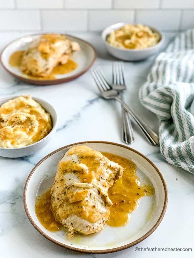 a plate of sliced turkey with bowls of mashed potatoes and more roasted turkey in the background.