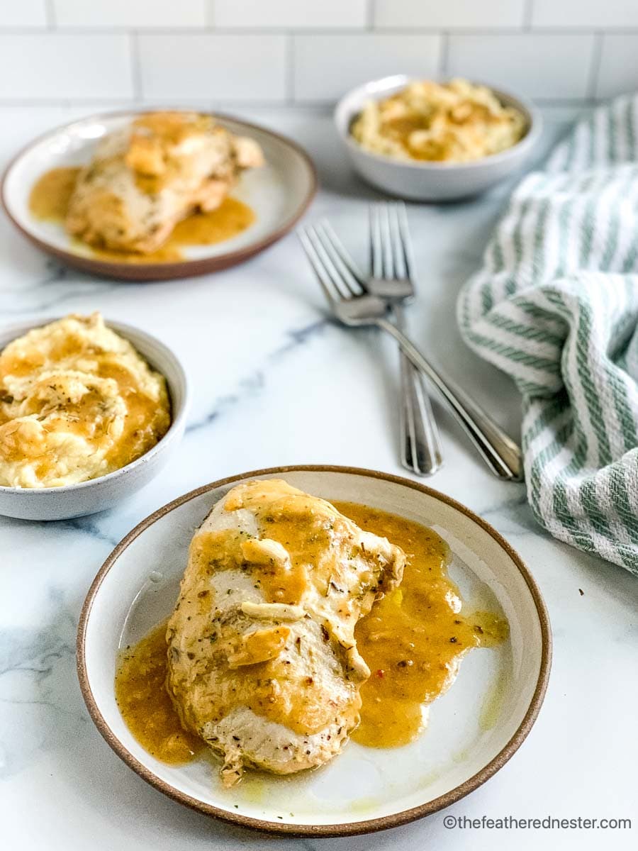 a plate of sliced turkey with bowls of mashed potatoes and more roasted turkey in the background.