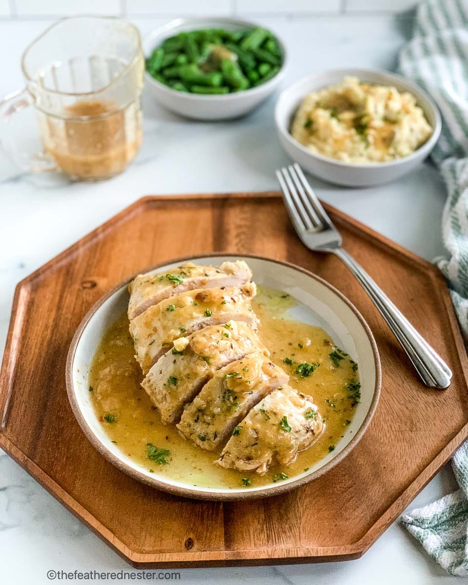 Plated crockpot turkey tenderloin covered with gravy.