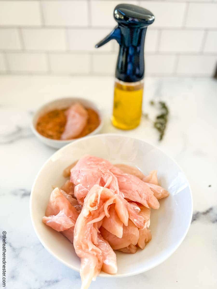 bowl of raw chicken strips.