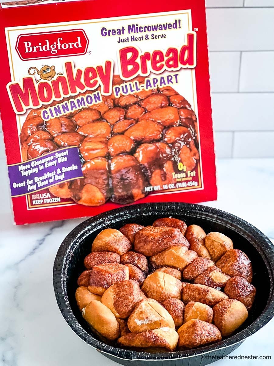 an oven ready container of monkey bread with a container of monkey bread in the background.