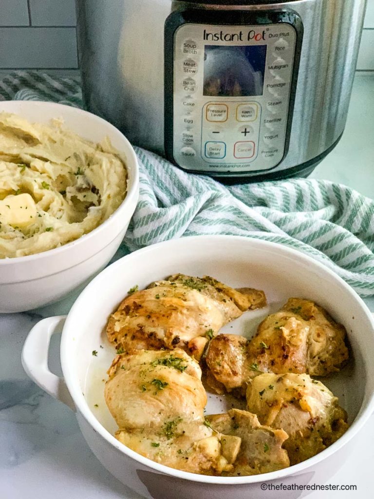 a serving platter of chicken thighs and bowl of mashed potatoes with an Instant Pot in the background