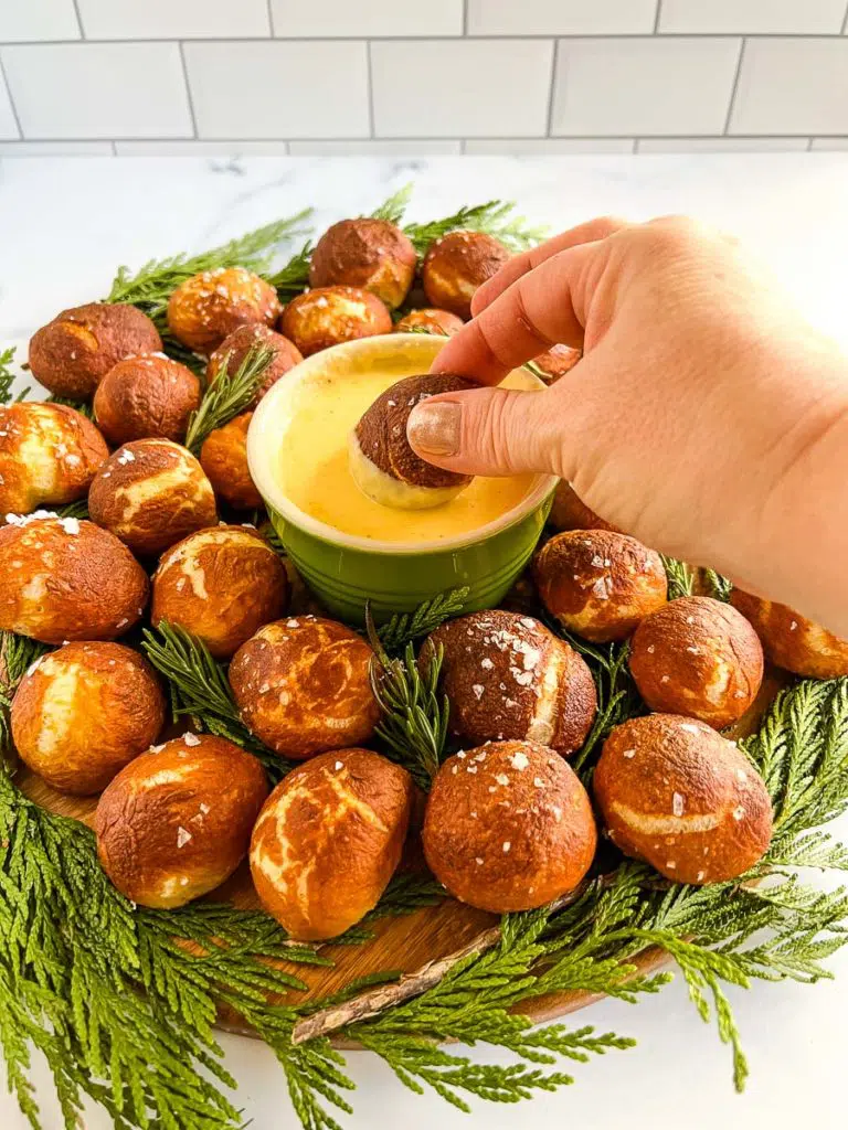 dipping a pretzel bite into cheesy beer dip