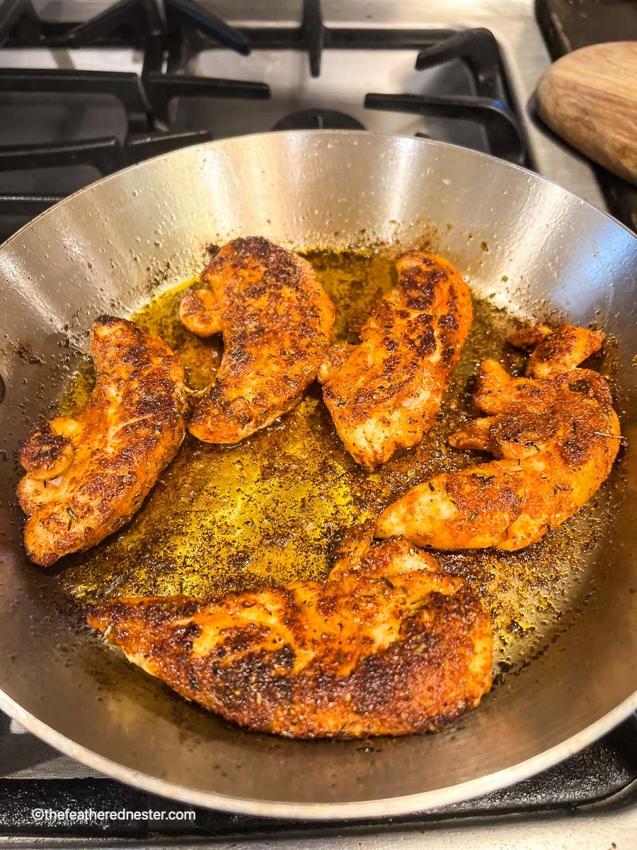 blackening chicken in a skillet.