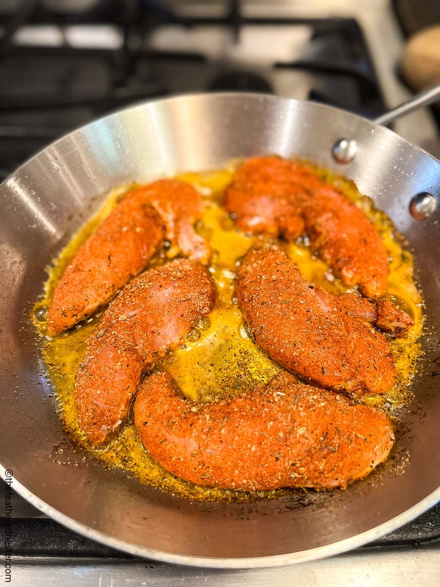 blackened chicken tenders in a cast iron skillet.