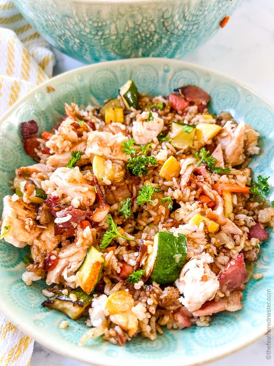 a green bowl of chicken fried rice.