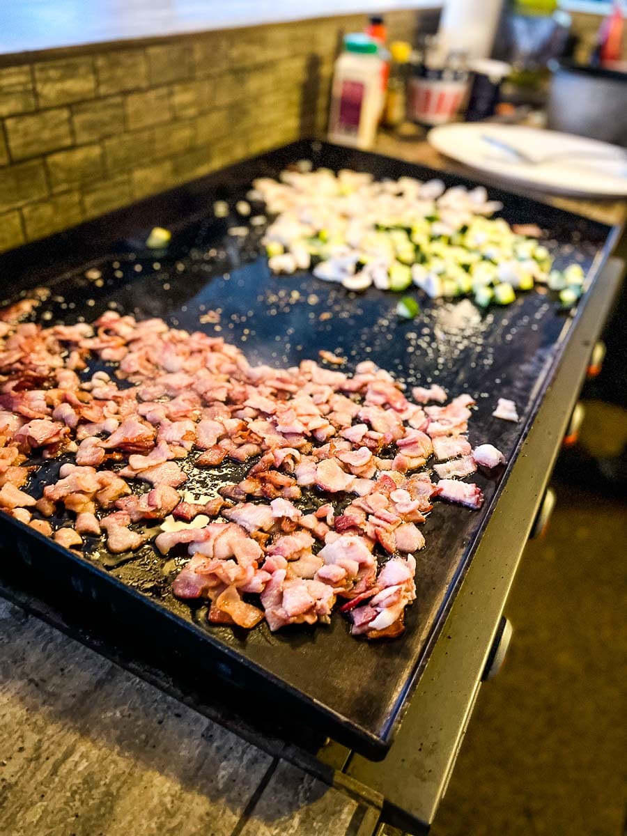 Bacon fried rice cooking on a hibachi grill.