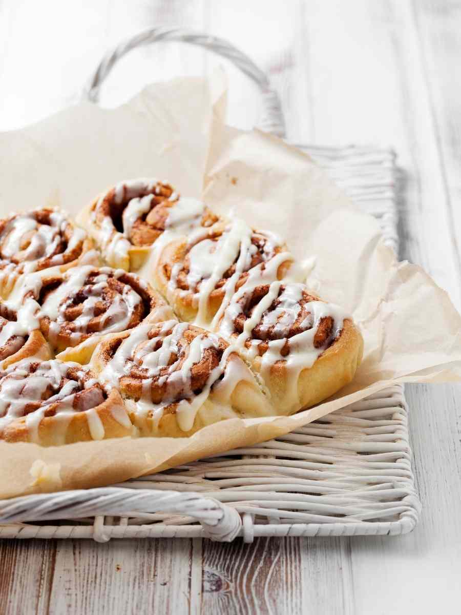 a baking sheet of frosted cinnamon rolls made with frozen bread dough.