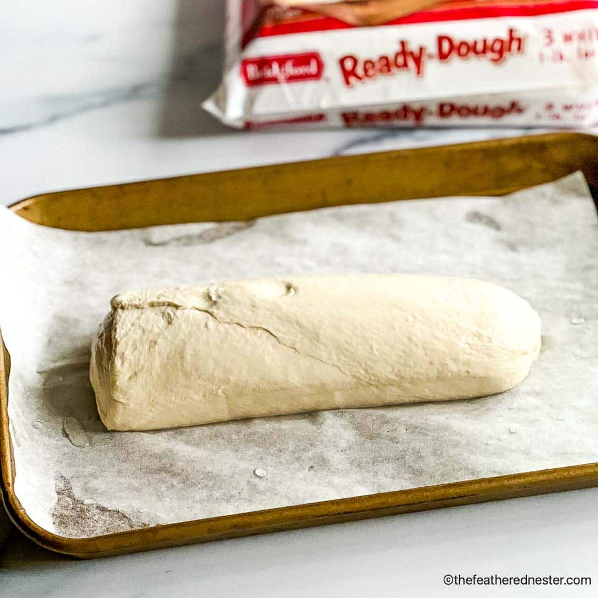 frozen bread dough on a baking sheet.