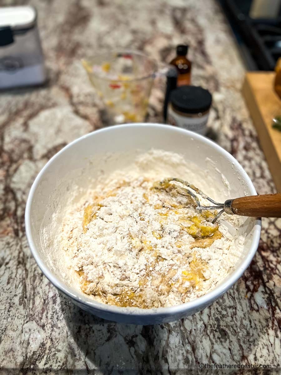 adding flour to the banana bread mixture in a large mixing bowl.