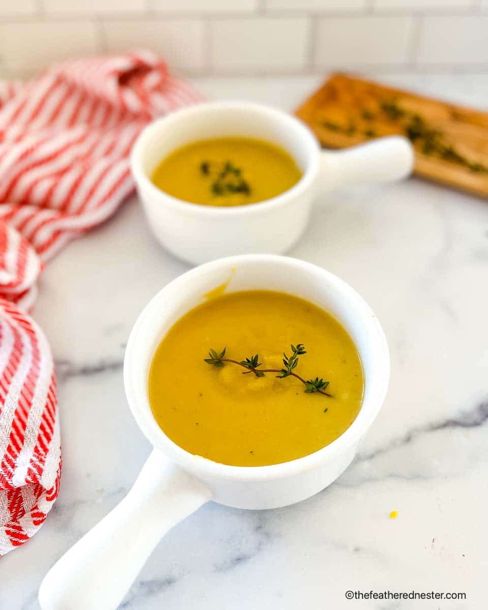 two white bowls with squash soup.