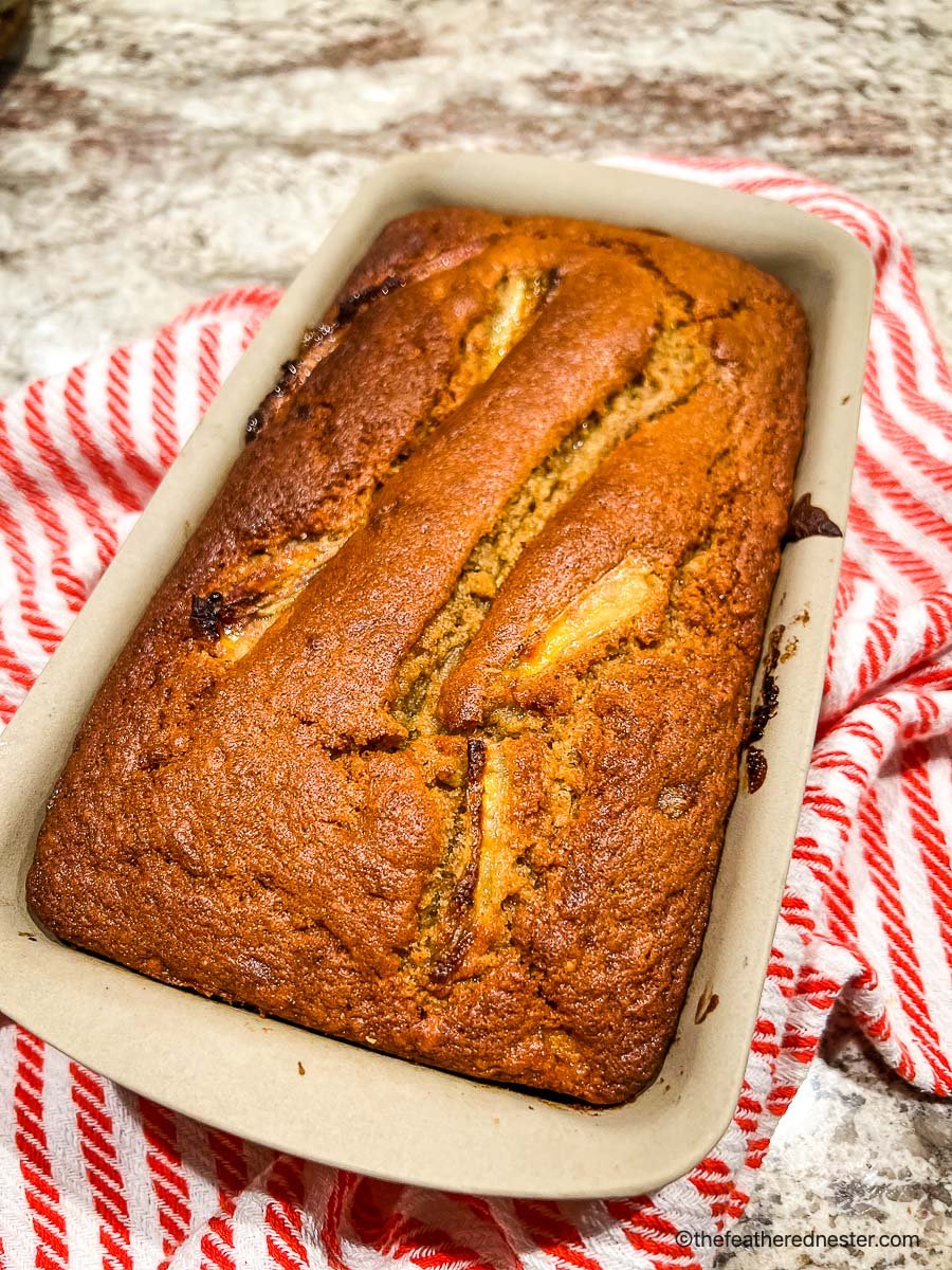 Freshly baked banana bread in a stoneware loaf pan.