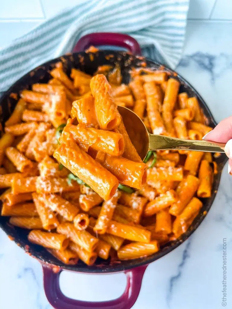 a casserole dish of spicy rigatoni with a closeup of a spoonful