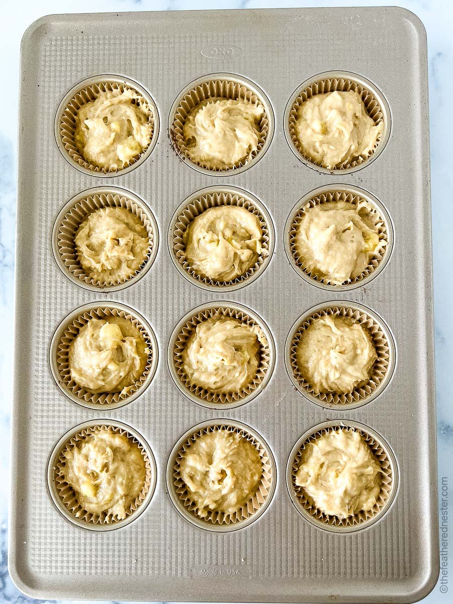 a muffin pan filled with muffin batter.