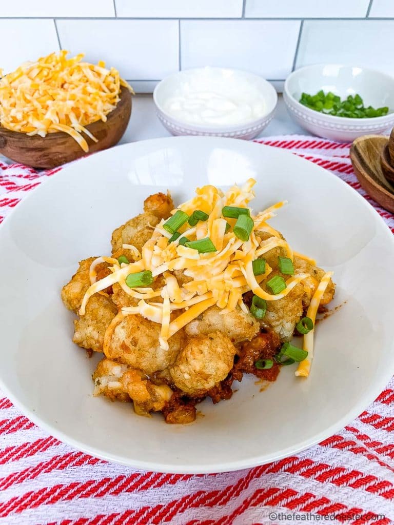 Serving of tater tot hotdish topped with cheese and scallions