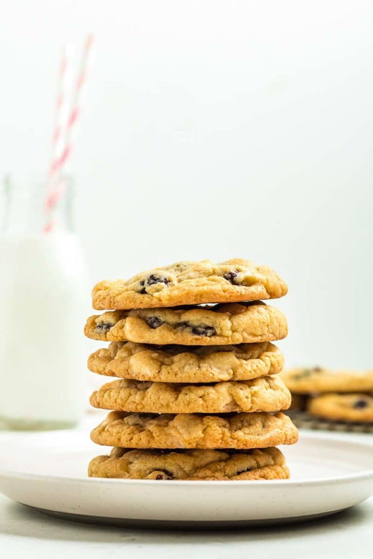 Plated stack of white chocolate raspberry cookies with a bottle of milk in the background