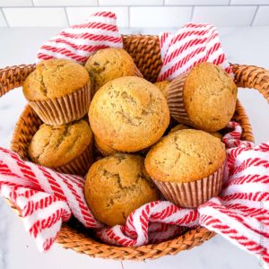 ourdough banana muffins in a wicker basket with a striped tea towel.