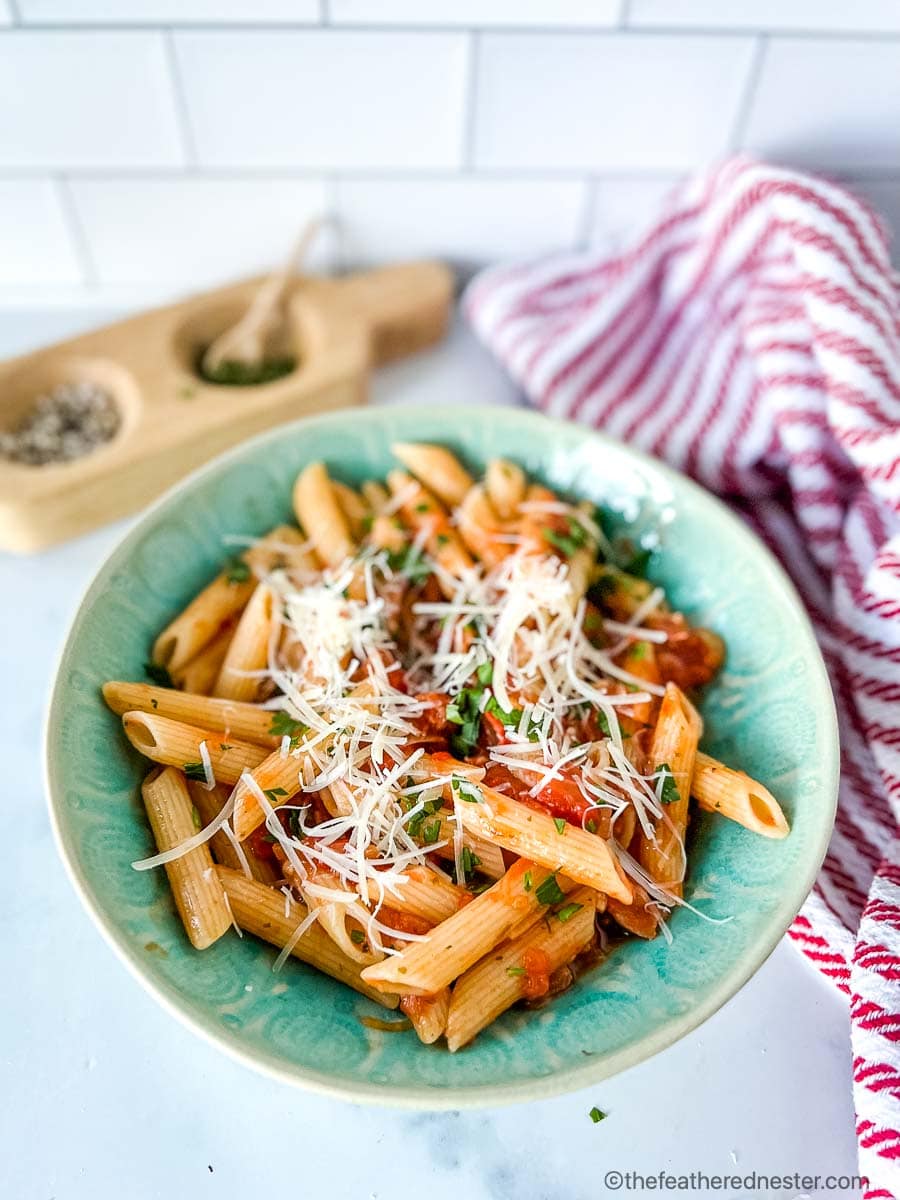 a bowl of noodles mixed with a rich Italian tomato sauce.