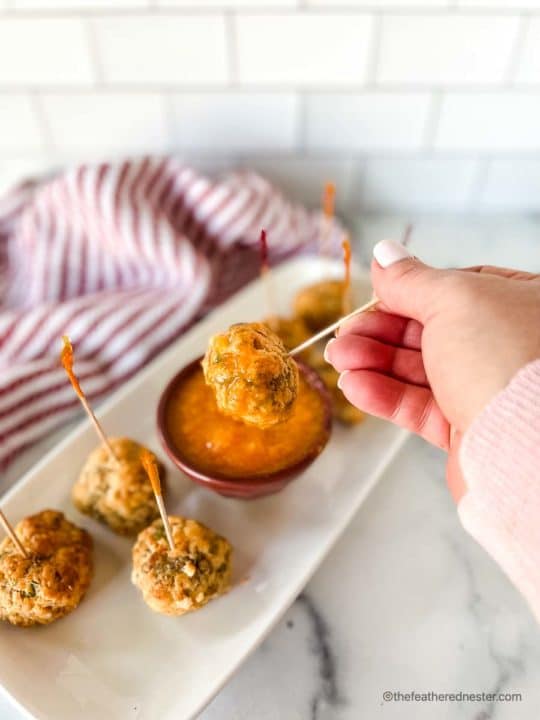 dipping an appetizer ball into mango sweet chili sauce
