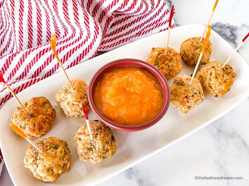 a tray of pimento cheese balls with sweet mango sauce