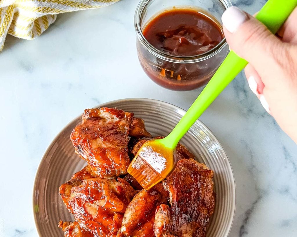 Basting the 3 Ingredient Homemade Honey BBQ Sauce on a Grilled chicken