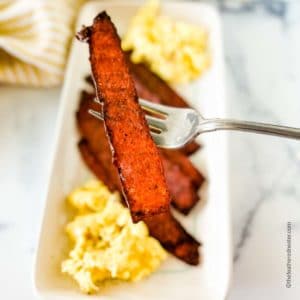 white platter with turkey bacon and scrambled eggs.