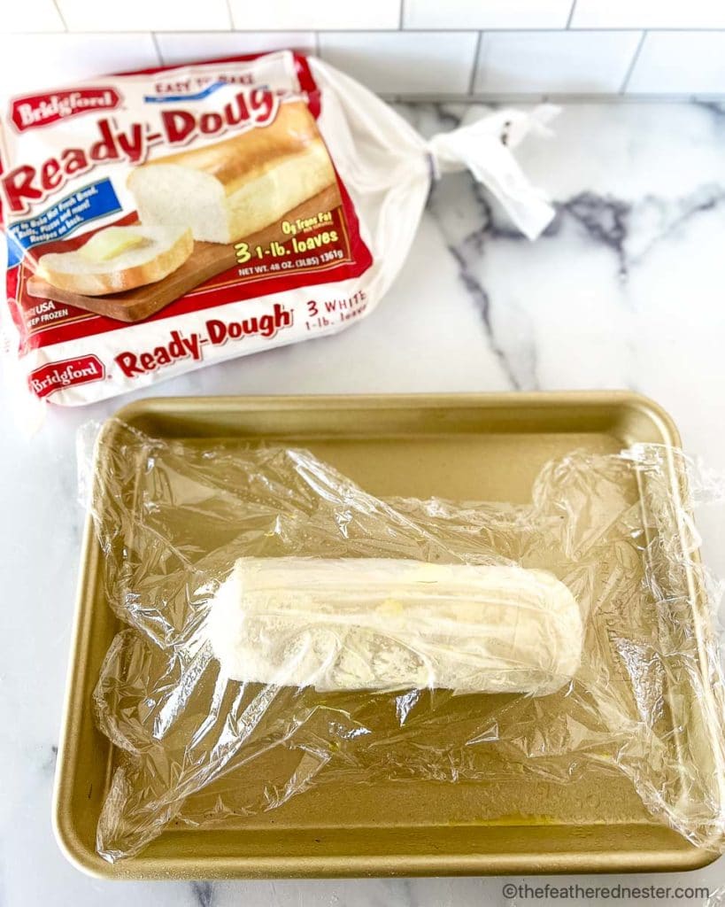 How to thaw frozen bread dough: a gold baking sheet with a loaf of Ready-Dough to thaw
