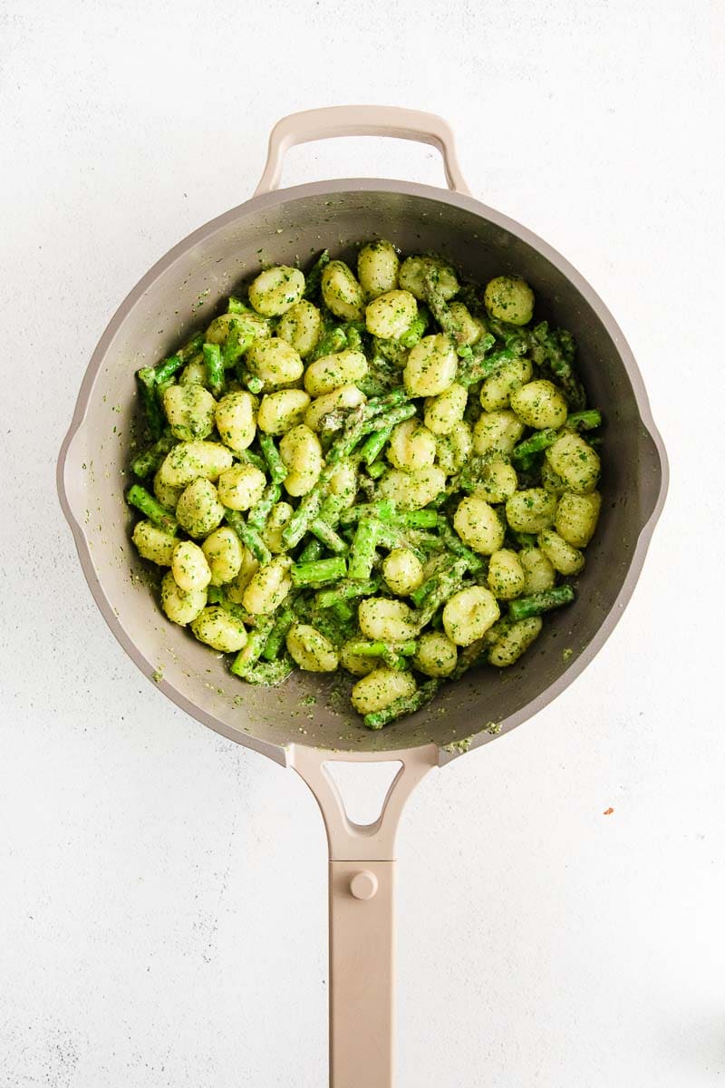 Looking down into a saucepan full of asparagus gnocchi.